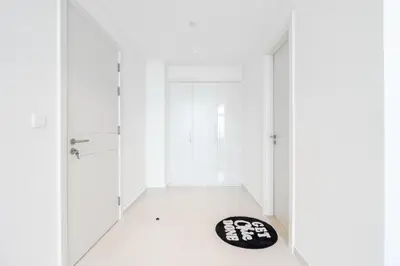a hallway with white walls and a black rug on the floor at Ahlan HH - Luxury 2BR Damac Tower 108 at High Floor in Dubai