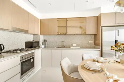 a kitchen with a wooden table and a dining room at Luxury 2BR at Grand Bleu in Dubai