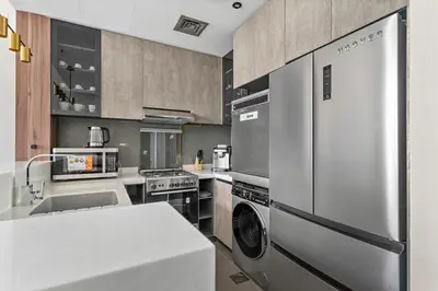a kitchen with a stainless steel refrigerator and a dishwasher at Stonetree - Cozy 1 BR at MBL Near Metro in Dubai