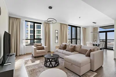 a living room with a couch and a tv at Stonetree - Spacious 2BR at Dubai Creek Residences in Dubai