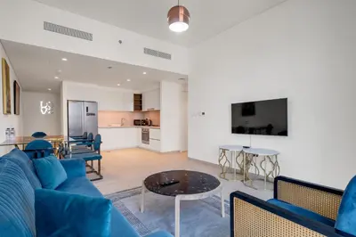 a living room with a blue couch and a table at Bellavista - 2 Bedroom Downtown Views II T2 in Dubai