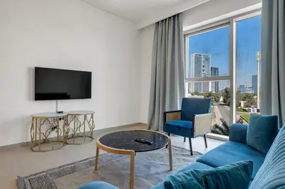 a living room with a blue couch and a tv at Bellavista - 2 Bedroom Downtown Views II T2 in Dubai