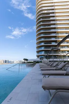a row of chaise lounges on the side of a building at 2BD designed by Elie Saab with Private Beach Sea View by EE Holiday Homes in Dubai