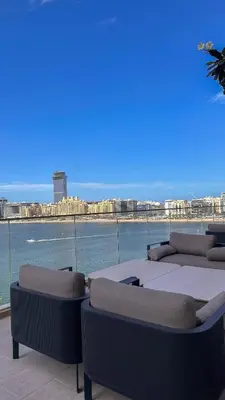 a balcony with chairs and a view of the water at 2BD designed by Elie Saab with Private Beach Sea View by EE Holiday Homes in Dubai