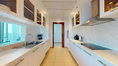 a kitchen with white countertops and a window at Paloma - Three Bed with Mesmerizing Marina View in Dubai