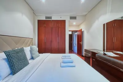 a bedroom with a large white bed and wooden cabinets at Dubai Marina, Beach & Marina View , 2 Bed Perfect for Groups in Dubai