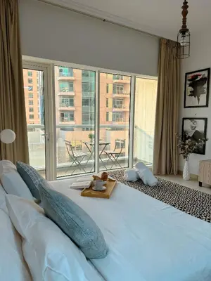 a large bed in a room with a large window at 5 minutes walk to Dubai mall and Burj Khalifa in Dubai