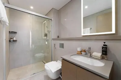 a bathroom with a sink and a shower and a toilet at Daniels 1BR at Waves Grande In Sobha Hartland in Dubai