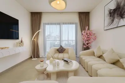 a living room with a couch and a table at Daniels 1BR at Waves Grande In Sobha Hartland in Dubai
