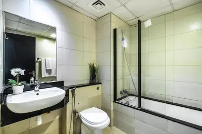 a bathroom with a sink and a toilet and a shower at Spacious 1-BR Opposite Mall with Huge Pool & Gym in Dubai