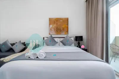 a bedroom with a bed with two rolled towels on it at Bloomfields Stylish Stu in Damac Ghalia in Dubai