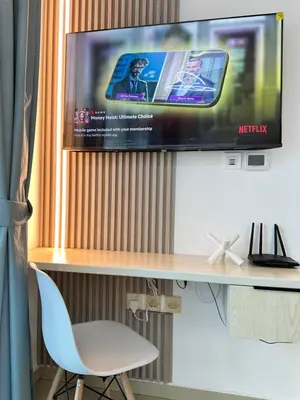 a tv on a wall with a desk and a chair at Stylish Studio with Stunning Marina Canal Views near to the Beach in Dubai