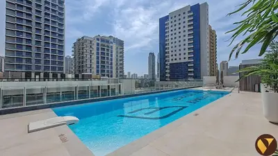 a swimming pool on top of a building with tall buildings at Vogue JVC Binghatti Galaxy near Circle Mall, Studio Apartment with Balcony and City View, Access to all Amenities in Dubai