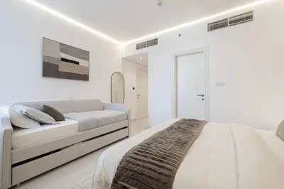 a white bedroom with a bed and a mirror at Downtown Views - For Big families & Groups - Up to 13 Guests - 6 min from Burj Khalifa in Dubai