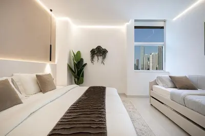 a white bedroom with a large bed and a window at Downtown Views - For Big families & Groups - Up to 13 Guests - 6 min from Burj Khalifa in Dubai