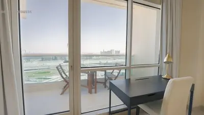a desk and chairs in a room with a large window at Great & huge apartment high floor! in Dubai