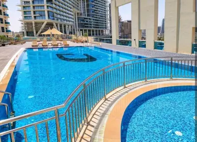 a large pool with blue water in a building at Great & huge apartment high floor! in Dubai