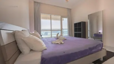 a bedroom with a bed with a stuffed animal on it at Great & huge apartment high floor! in Dubai