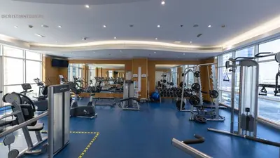 a gym with treadmills and machines in a building at Great & huge apartment high floor! in Dubai