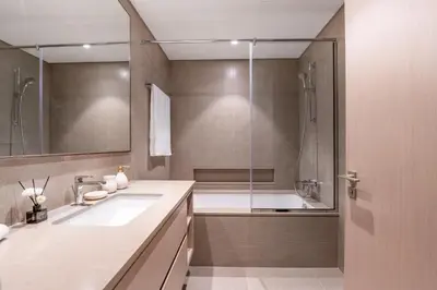 a bathroom with a shower and two sinks and a tub at Hermes-Style 2BR, Full Burj Khalifa View - Infinity Pool - Full Fountain View in Dubai