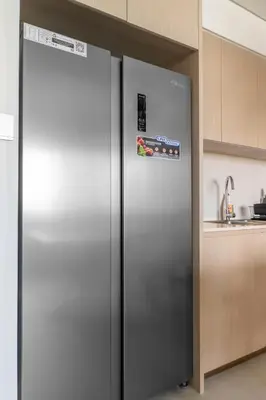 a stainless steel refrigerator in a kitchen at Hermes-Style 2BR, Full Burj Khalifa View - Infinity Pool - Full Fountain View in Dubai