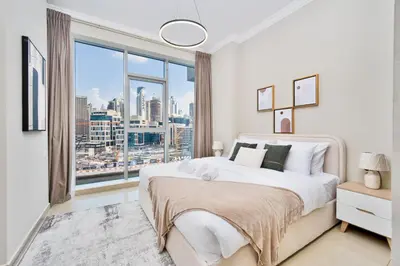 a bedroom with a large bed with a large window at 1BR Stunning Canal & Burj view, Luxury Stay at Fairview Residency in Dubai
