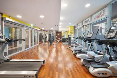 a gym with a row of cardio machines at 1BR Stunning Canal & Burj view, Luxury Stay at Fairview Residency in Dubai