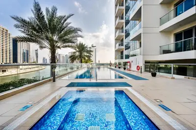 a swimming pool in the middle of a building at 1BR Stunning Canal & Burj view, Luxury Stay at Fairview Residency in Dubai