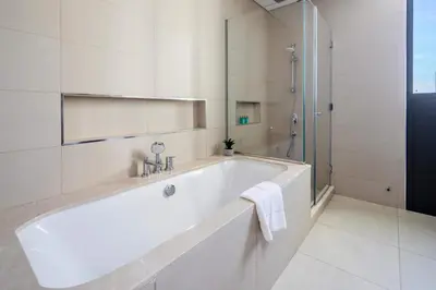a white bath tub in a bathroom with a shower at Frank Porter - Downtown Views in Dubai