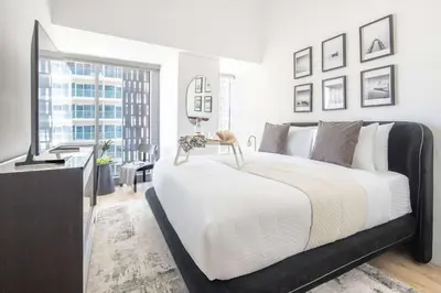 a bedroom with a large bed and a television at Frank Porter - Cayan Tower in Dubai