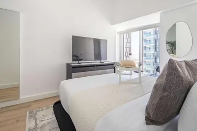 a bedroom with a bed and a mirror and a tv at Frank Porter - Cayan Tower in Dubai