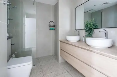 a bathroom with two sinks and a toilet and a mirror at Frank Porter - Cayan Tower in Dubai