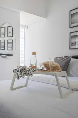 a white coffee table in a white room with a bed at Frank Porter - Cayan Tower in Dubai