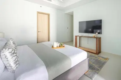 a bedroom with a large bed and a flat screen tv at Frank Porter - Paramount Midtown in Dubai