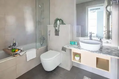 a bathroom with a toilet and a sink and a tub at Frank Porter - Paramount Midtown in Dubai