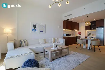 a living room with a white couch and a table at HiGuests - Elegant 1BR Retreat with Sea View in La Rive in Dubai