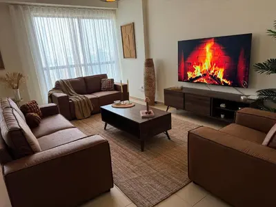 a living room with a large tv and a fireplace at Best view homes in Dubai