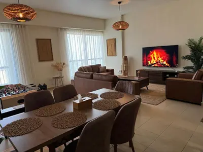a living room with a fireplace and tables and chairs at Best view homes in Dubai