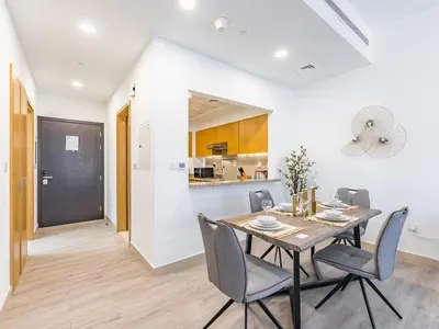 a dining room with a table and chairs and a kitchen at Modern Retreat with Balcony and Burj Khalifa View in Dubai