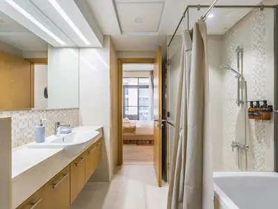 a bathroom with two sinks and a tub and a shower at Modern Retreat with Balcony and Burj Khalifa View in Dubai