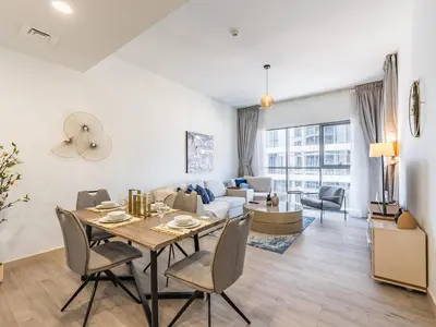 a living room with a table and chairs and a couch at Modern Retreat with Balcony and Burj Khalifa View in Dubai