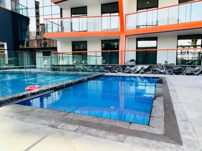a swimming pool in front of a building at Community View 1BR with Balcony Near Downtown Dubai, Binghatti Avenue, Al Jaddaf by Deluxe Holiday Homes in Dubai