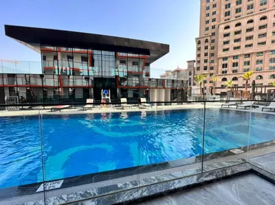 a large swimming pool in front of a building at Community View 1BR with Balcony Near Downtown Dubai, Binghatti Avenue, Al Jaddaf by Deluxe Holiday Homes in Dubai