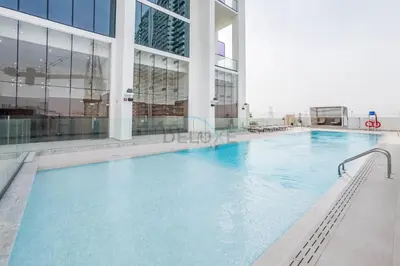 a large swimming pool inside of a building at City Views 1BR with Private Balcony, Binghatti House, Jumeirah Village Circle by Deluxe Holiday Homes in Dubai