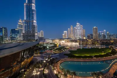 a view of a city at night with tall buildings at Hermes-Style 2BR, Full Burj Khalifa View - Infinity Pool - Full Fountain View in Dubai