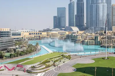 a view of a city with a fountain and buildings at Hermes-Style 2BR, Full Burj Khalifa View - Infinity Pool - Full Fountain View in Dubai