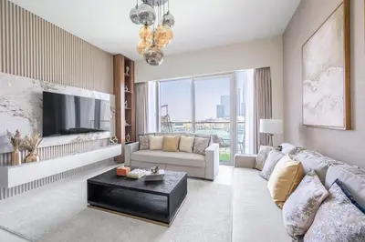 a living room with a couch and a tv at Hermes-Style 2BR, Full Burj Khalifa View - Infinity Pool - Full Fountain View in Dubai