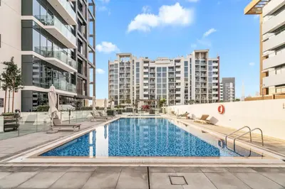 an image of a swimming pool with buildings in the background at GuestReady - Riviera Studio | Burj Khalifa view in Dubai