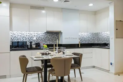 a white kitchen with a table and chairs at The Highest Infinity Pool in Downtown Dubai in Dubai