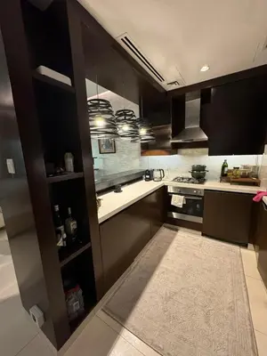 a kitchen with dark brown cabinets and a stove at Bright and Airy 2BR Bay Retreat in Dubai